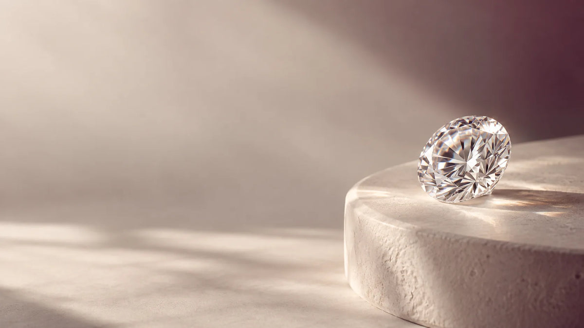 A brilliant-cut lab grown diamond resting on a stone plinth in soft window light